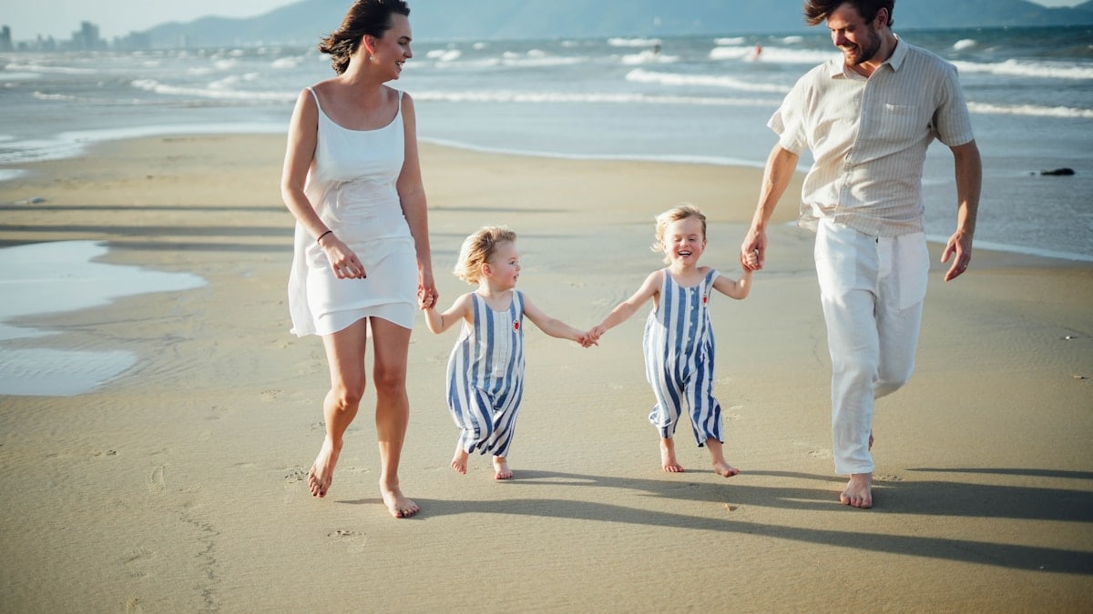 Family walking on a beach at sunset
